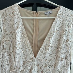 Tobi M white with crème underlay long sleeve zip up back. Cute flip skirt hem